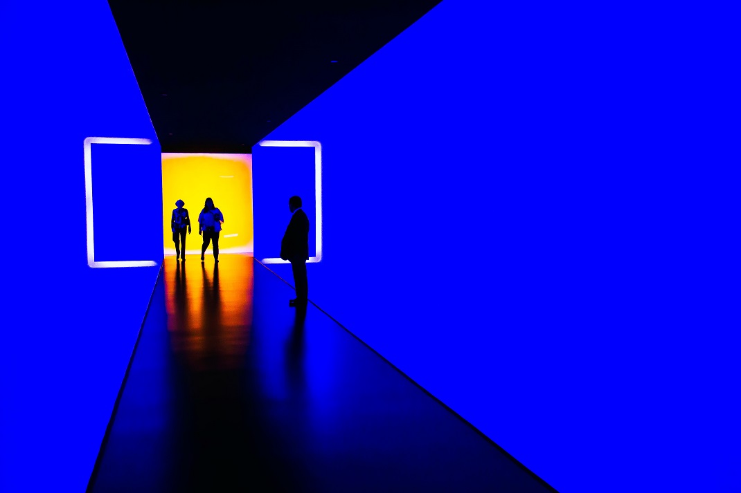 Three persons standing near wall inside futuristic building by Werner Du plessis